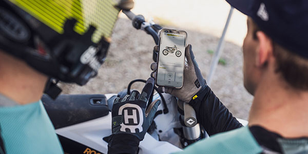 Riders looking at the Connectivity Unit Offroad, Ride Husqvarna app