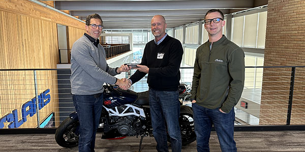 Accepting the trophy from Pied Piper CEO Fran O’Hagan (center) were Joel Harmon, Polaris vice president, on-road sales and market development (left) and Aaron Jax, vice president, Indian Motorcycle (right).